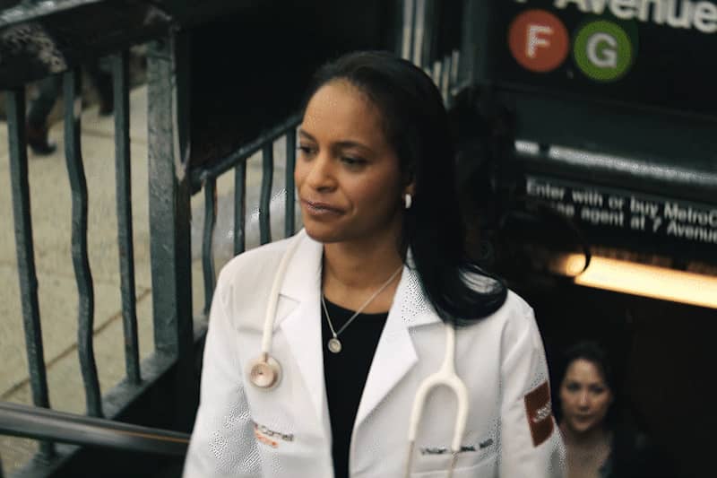 a female doctor walking out of the subway station